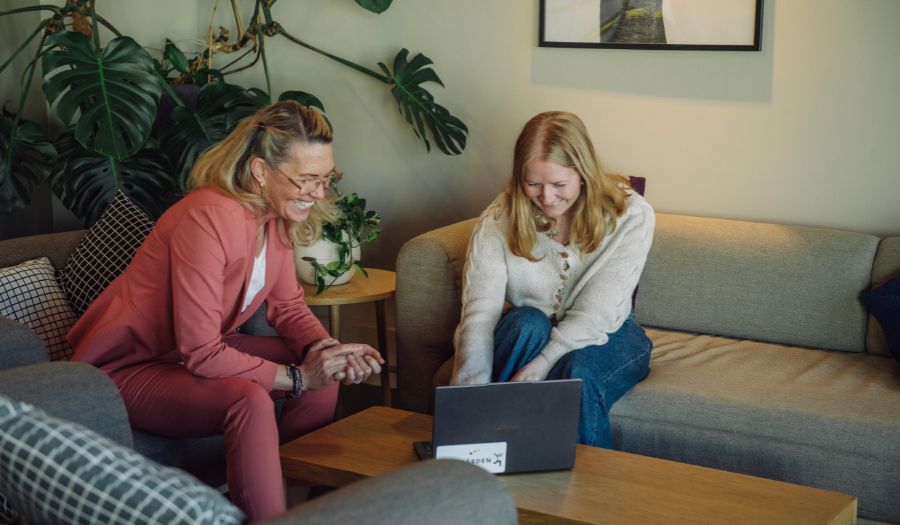 To personer som ser på en PC og smiler To personer som ser på en PC og smiler
